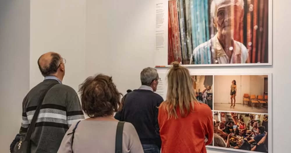 Photograph of four people facing photography exhibit in Hungary Museum