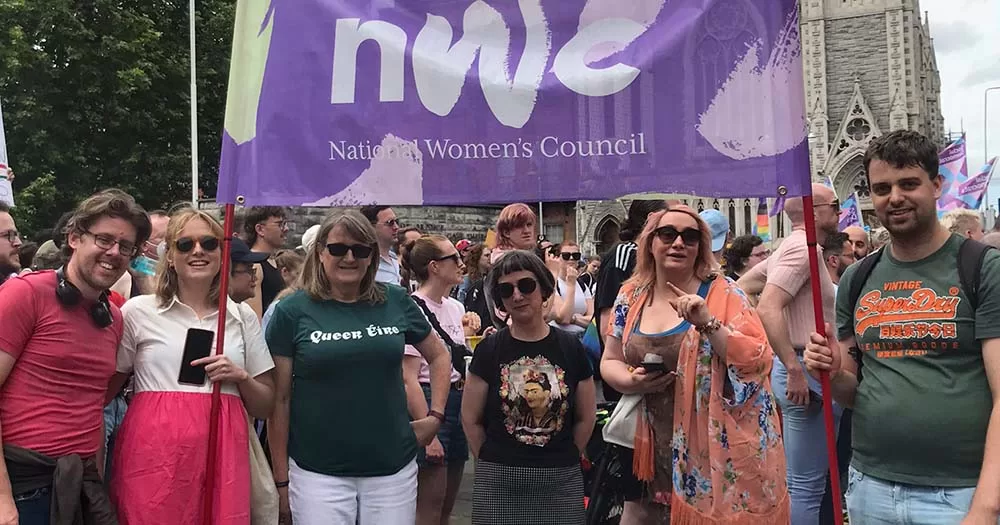 Members of the National Women's Council stand with NWC flag, they recently won the conduct case brought about by anti-trans protestor.