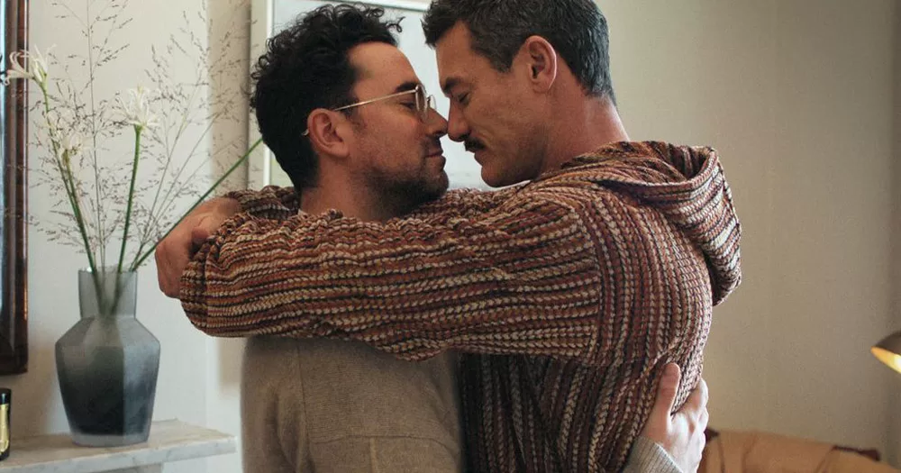A screencap from Netflix's 'Good Grief' showing actors Dan Levy and Luke Evans sharing a warm embrace