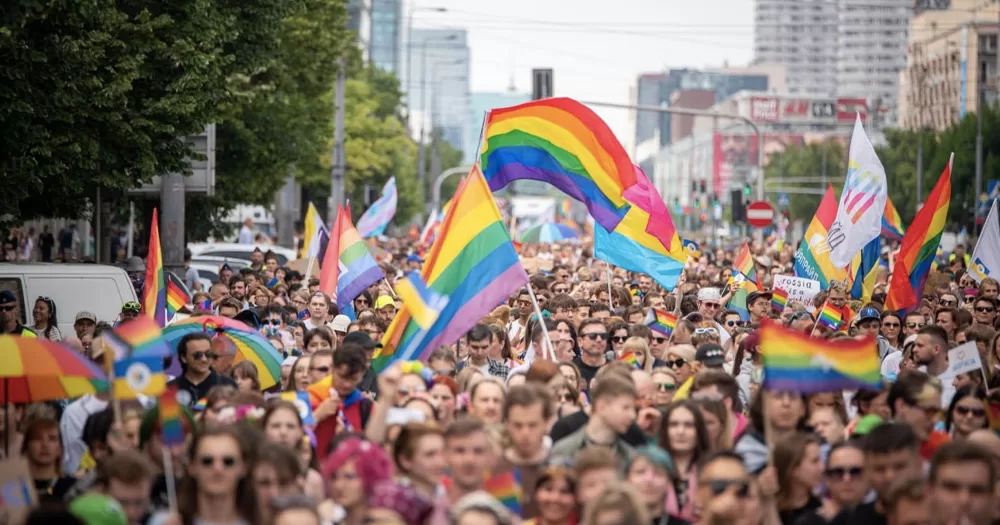 Pride parade in Warsaw, Poland, where same-sex unions are not legally recognised. A lot of people march in the streets, waving Pride flags.