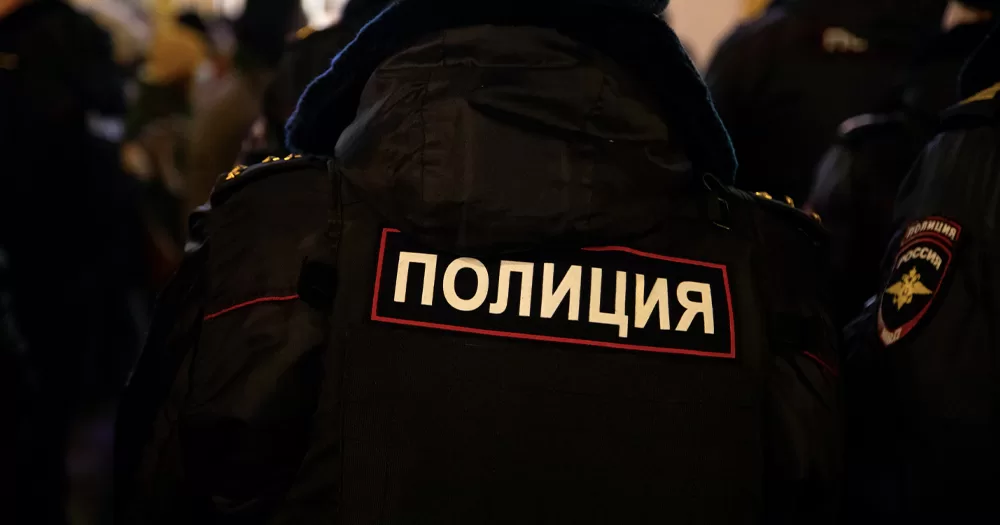 This article is about raids conducted in LGBTQ+ bars by Russian police. In the photo, the back of an officer wearing a uniform with the word 
