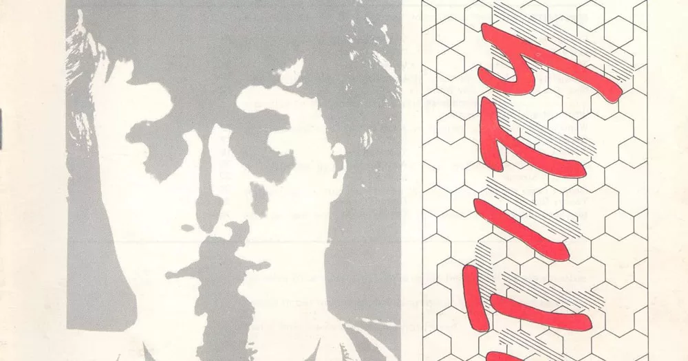 The image shows part of the cover of the first issue of Identity, an LGBTQ+ periodical. On the left of the image is a grey scale negative image of a man's face with his eyes closed. on the right, written sideways from bottom to top are the letters T I T Y. They are written in bright red in a bubble handwritten font.