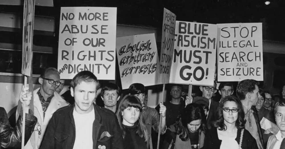 Photograph of peaceful protestors marching after the Black Cat Tavern raid in 1967