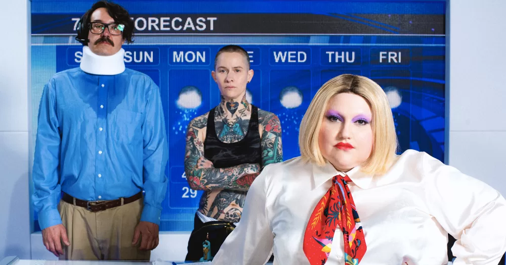 Music trio Gossip, coming to Dublin in August, standing in front of a forecast screen and looking at the camera.