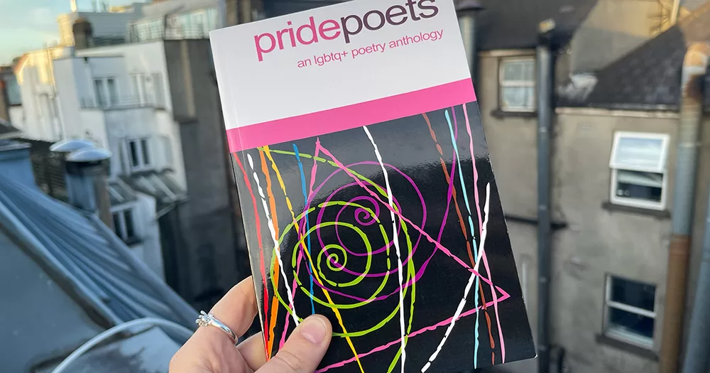 A hand holding the Pride Poets anthology.