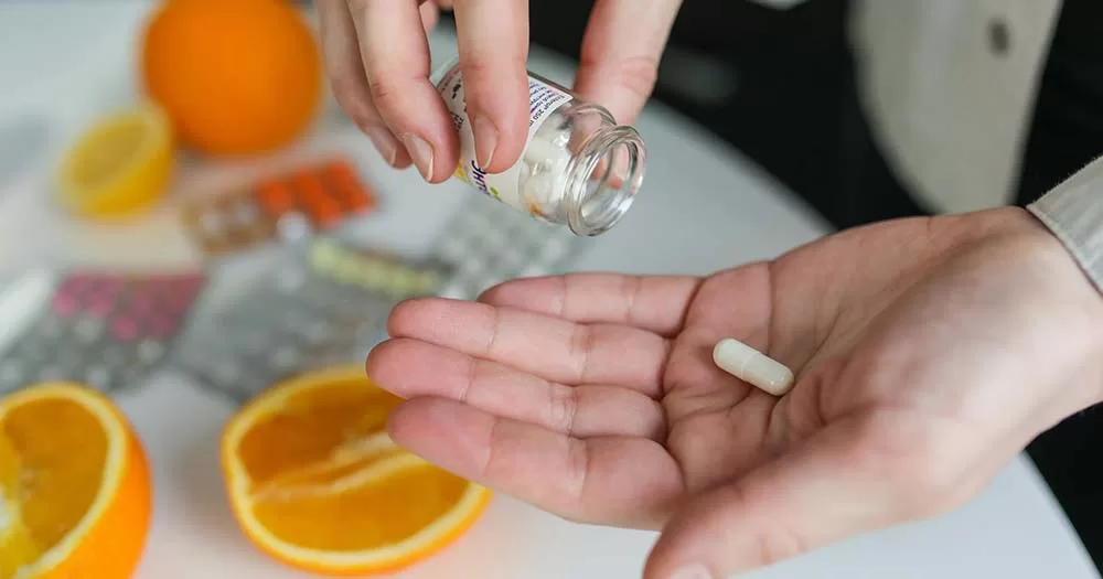 Photo of hand holding pill representing puberty blockers that the NHS will stop prescribing