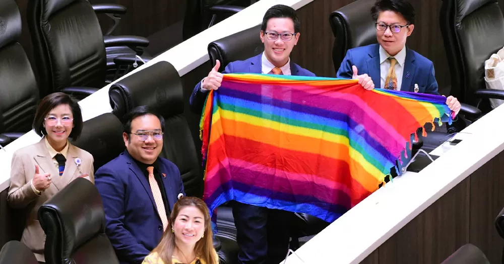 This article is about Thailand passing a bill to legalise same-sex marriage. In the photo, Thai lawmakers in parliament holding a Pride flag scarf.