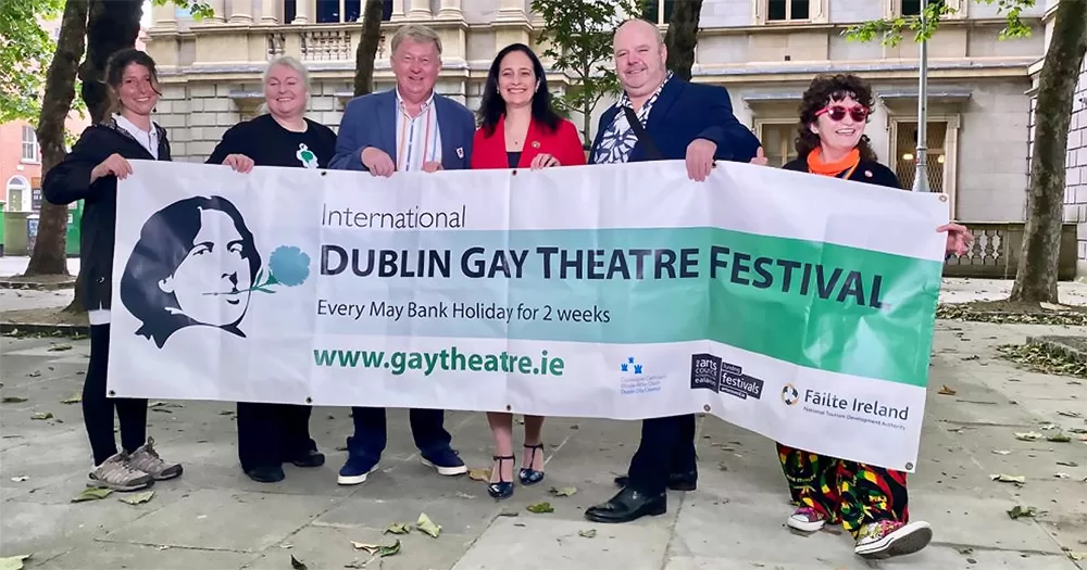 The image shows the organizers of the Dublin Gay Theatre Festival holding a banner.