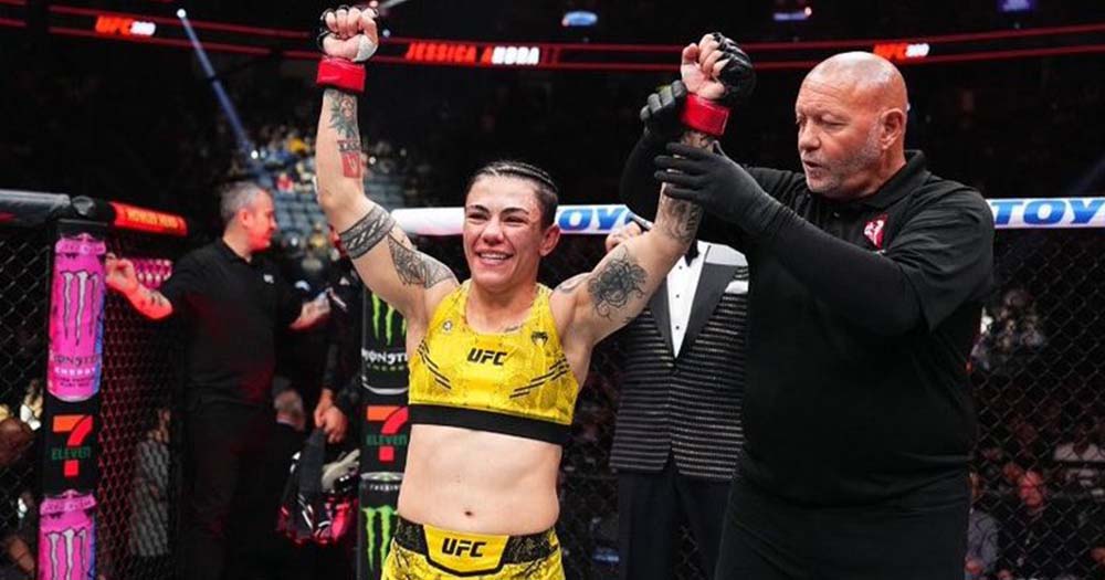 Photo of Jessica Andrade posing with her hands up after winning her fight in the ring