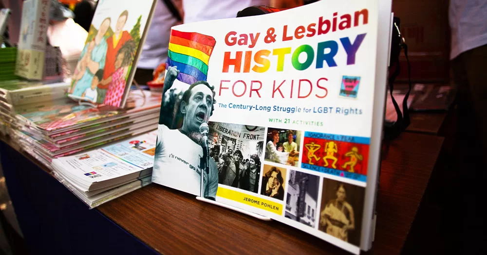 This article is about libraries in Northern Ireland. In the photo, some LGBTQ+ books on a table, including one titled 