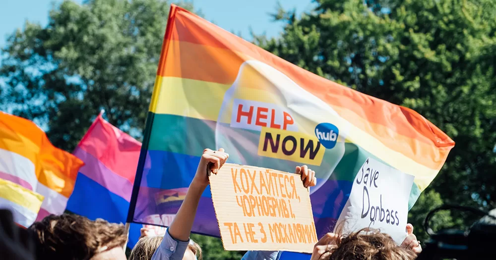 The picture shows protesters holding antiwar and LGBTQ+ flags in reaction to Russia's situation.