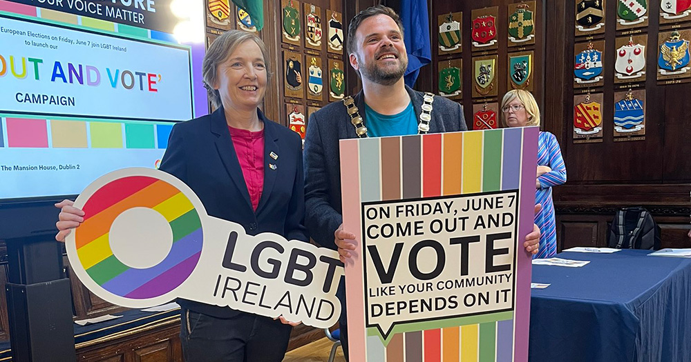 An image from LGBT Ireland's campaign launch encouraging people to vote in upcoming elections. Paula Fagan stands on the left holding an LGBT Ireland sign, while the Lord Mayor of South Dublin stands on the right holding a campaign sign.