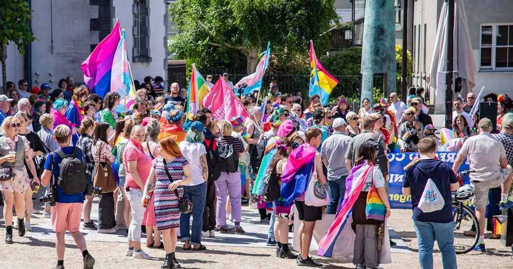Photo taken at Pride of the Déise with people marching with Pride flag on the street