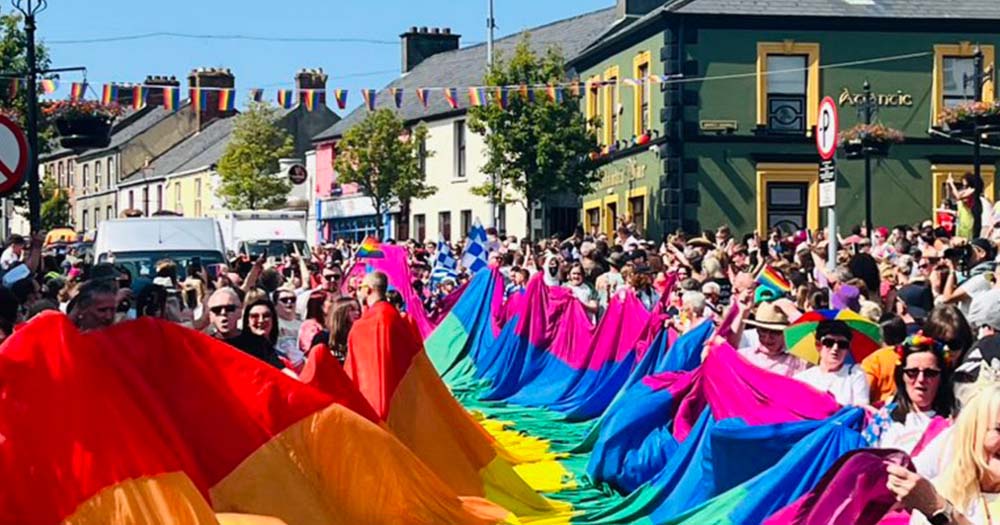 Photo of people carrying giant Pride flag in rural Ireland representing the new Rowan Trust funding initiative