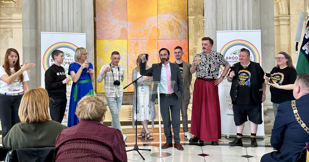 Photo of Dublin Pride team at the launch of the 2024 festival, with Jed Dowling addressing the crowd and the other members smiling and cheering.
