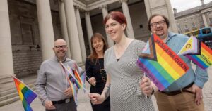 Photo of BOI team members holding Pride flags representing upcoming financial workshops for the LGBTQ+ community