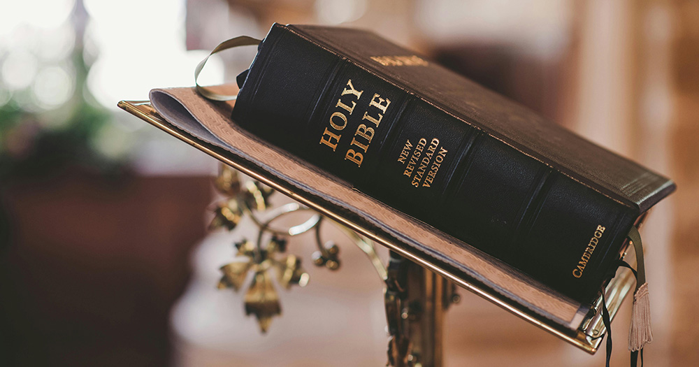 This article is a out the Methodist Church in Ireland apologising to the LGBTQ+ community. The image shows a black Holy Bible resting on stand.