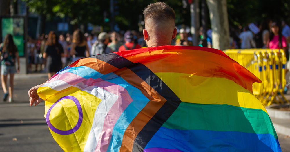 This article is about the MyLife Pride Challenge. In the photo, the back of a person carrying a Pride flag.