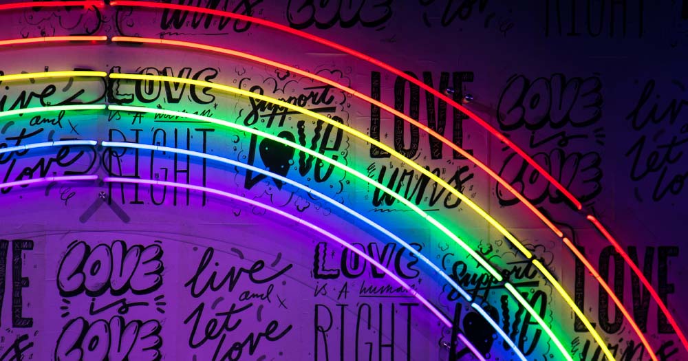 Photo of rainbow led lights over 'love is love' and 'support love' text.