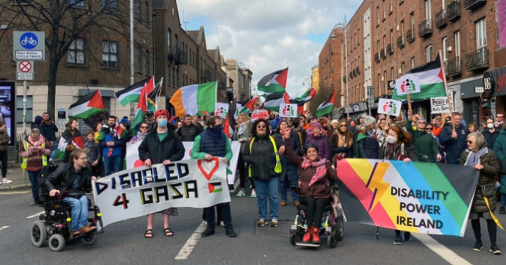 A gathering of people holding banners reading "Disabled 4 Gaza" and "Disability Power Ireland" at Dublin's Disability and Power Pride Parade.