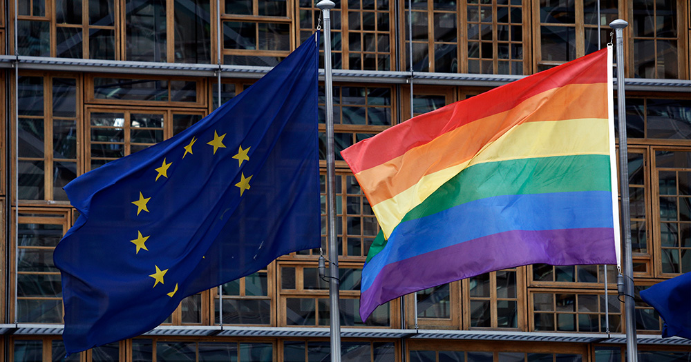 An EU and LGBTQ+ Pride flag flying side by side.