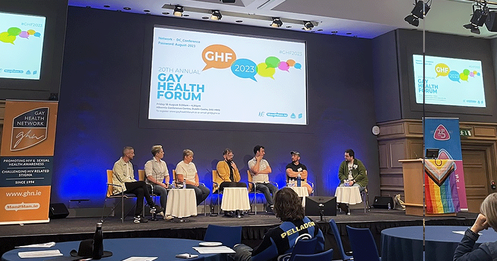 Photo from the Gay Health Forum, which have just announced their 2024 programme, showing people during a panel discussion in a big room.