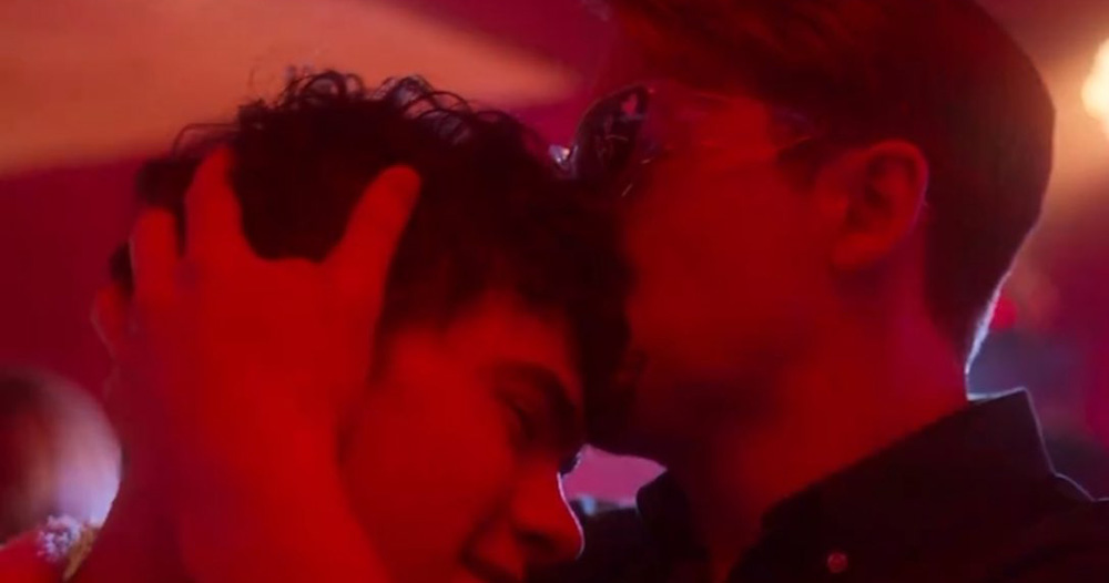A screenshot from a Heartstopper Season 3 clip showing Nick (Kit Connor) kissing Charlie (Joe Locke) on the forehead.