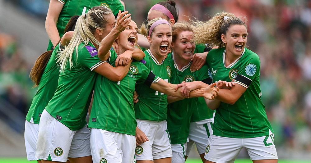 Players on the Ireland women's football team celebrate a goal against France.