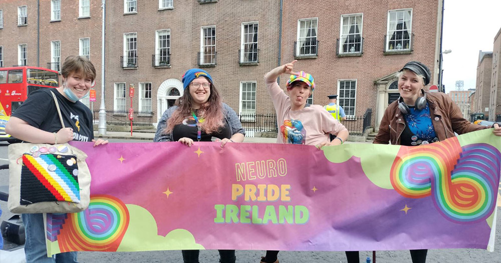 People holding a 'Neuro Pride Ireland' banner in the streets of Dublin, Ireland.