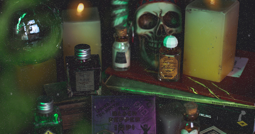 A table set up with witchcraft items including small spell jars and a skull.