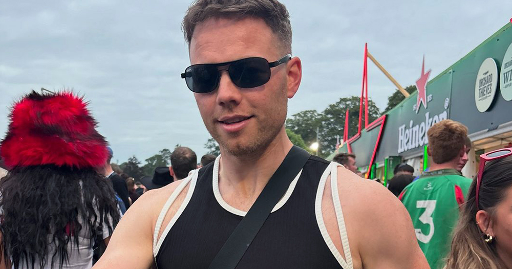 Influencer Cian Griffin posing at Electric Picnic, where he said he experienced several incidents of homophobia. In the photo, he is standing in a crowd wearing a black tank top and sunglasses.