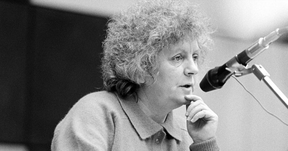 Irish journalist Nell McCafferty speaking in a microphone in a black and white photo.