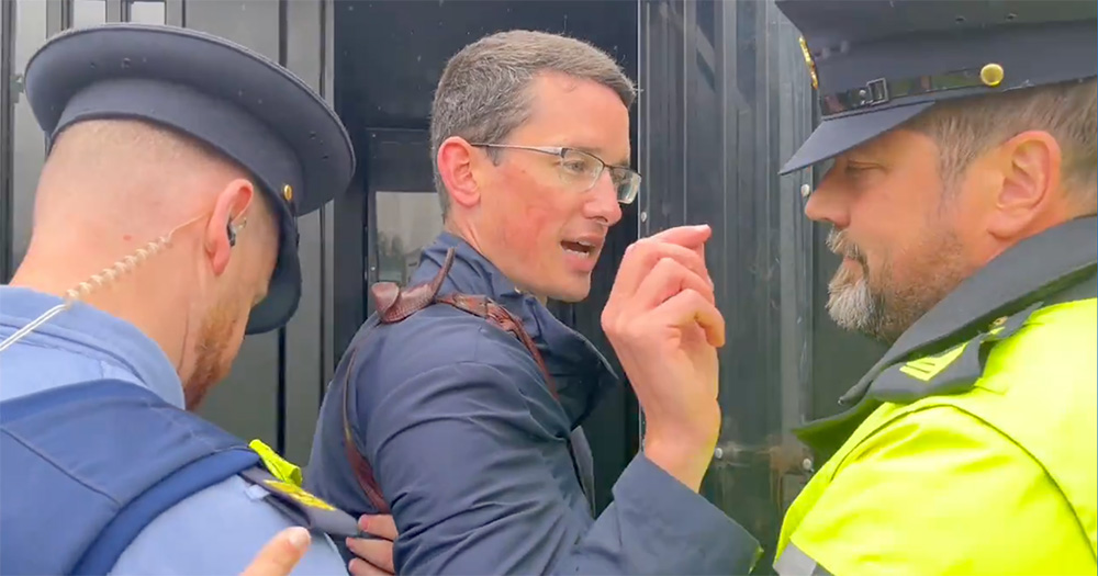 Enoch Burke being arrested before being jailed for a third time. The image shows Burke in the middle, with Gardaí on either side.