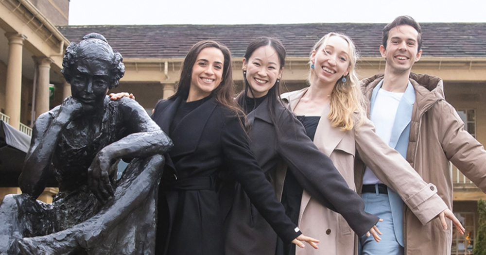 the performers of the new ballet production posing next to a statue of Anne Lister