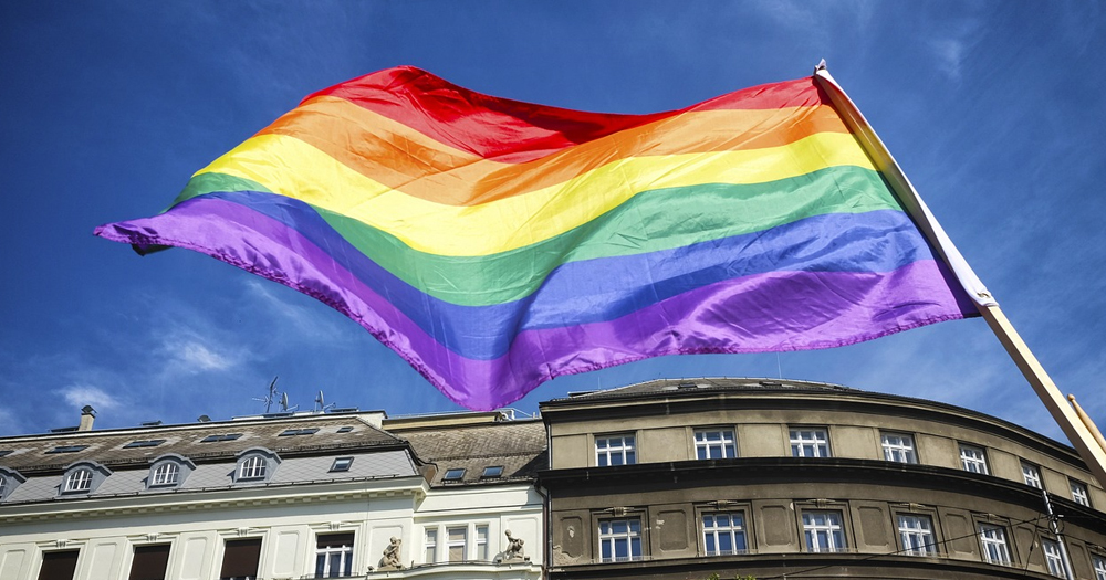 An LGBTQ+ flag fluttering in a queer-friendly country