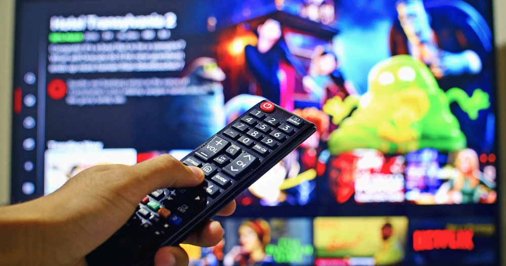 A remote control pointing towards a television screen