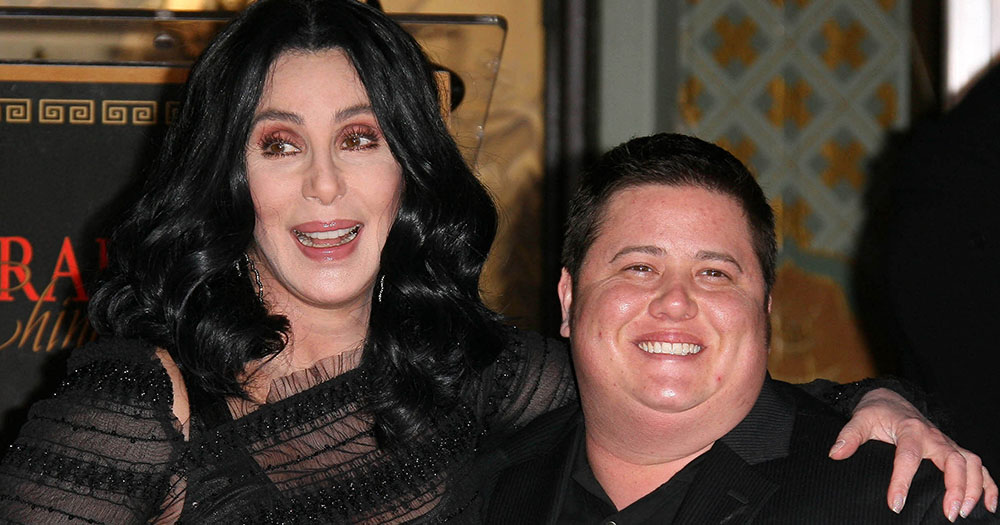 Celebrities Cher and her son, Chaz standing side by side smiling.