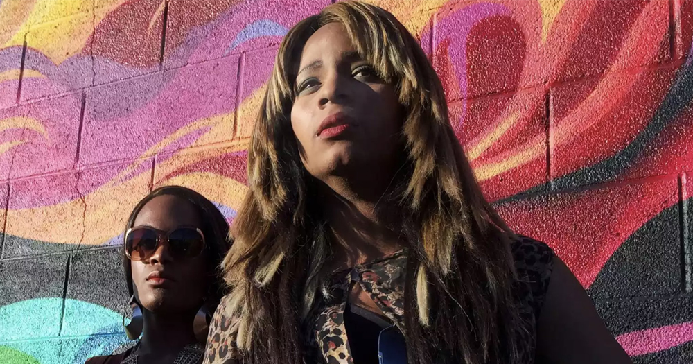 Screenshot of film Tangerine, with the protagonist and another character with a pink background.