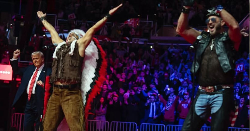 Photo of the members of The Village People, the Native American character, the biker character performing on stage, YMCA, in front of U.S. President Trump in front of a large crowd.