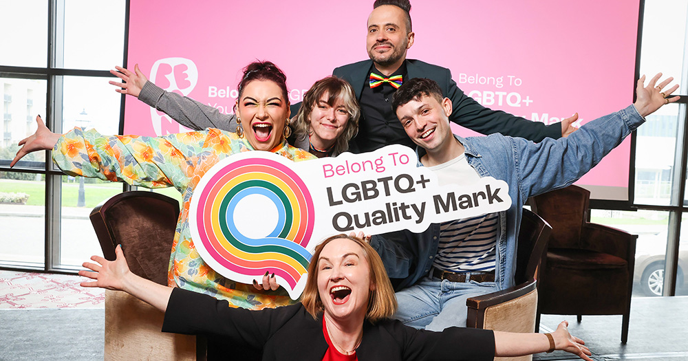 People cheering at the Belong To LGBTQ+ Quality Mark ceremony, recognising schools in Ireland for contributing to inclusion.