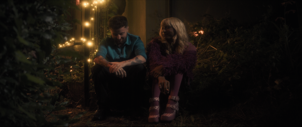 Photo shows Jay and Ruby sitting down together outside a house
