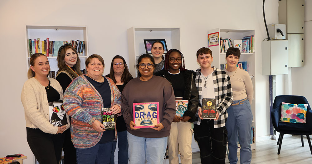 The GOSHH team standing in front of their new library.