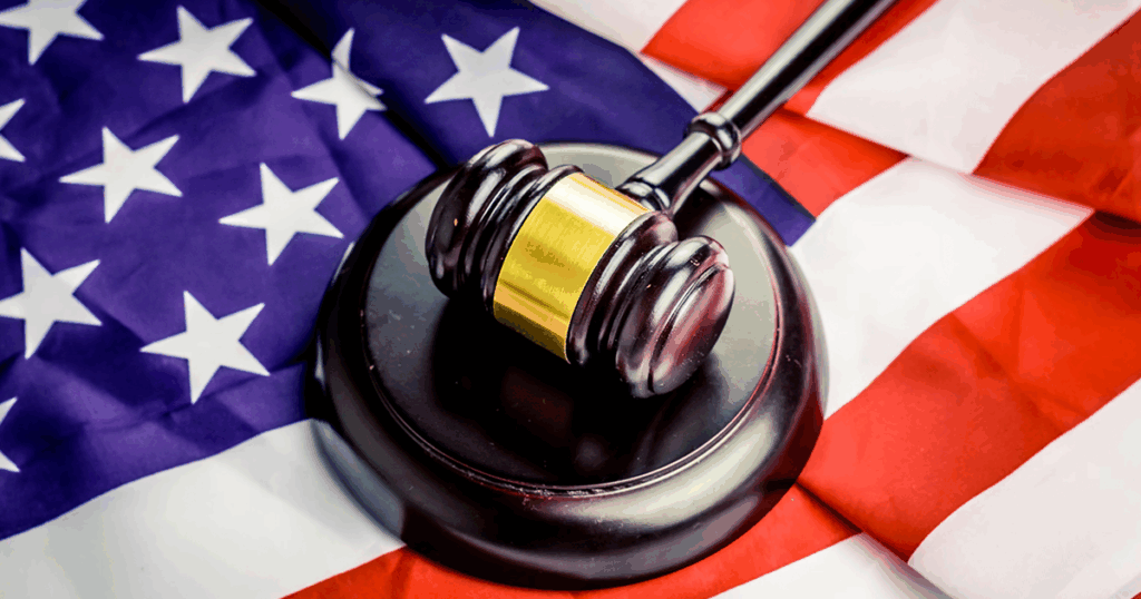 the image shows the United States Flag over a judges gavel and sound block - A United States federal judge has ordered the government to bring back a gay asylum seeker who was wrongfully deported under the Trump administration in violation of his legal protections.