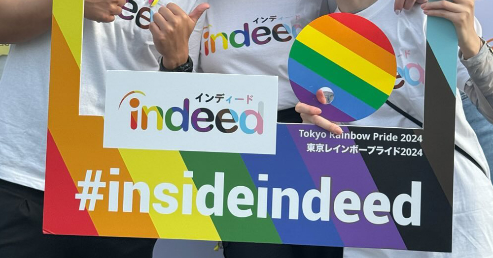 This article is about Indeed withdrawing from Dublin Pride. In the photo, people posing with a Pride banner with Indeed's logo on it.