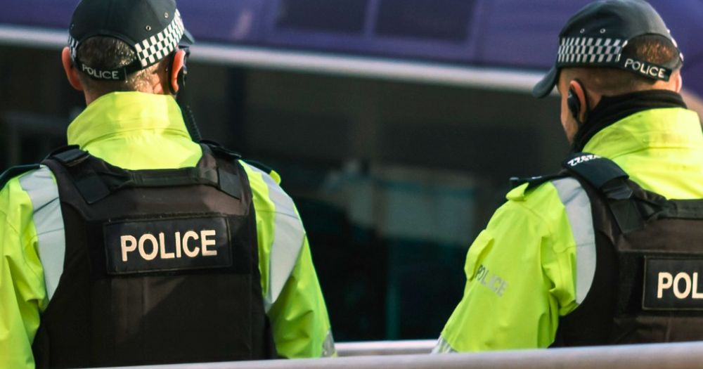 This article is about a Northern Irish police officer being fined for homophobic harassment. In the photo, two police officers in uniform seen from the back while they walk in the streets.