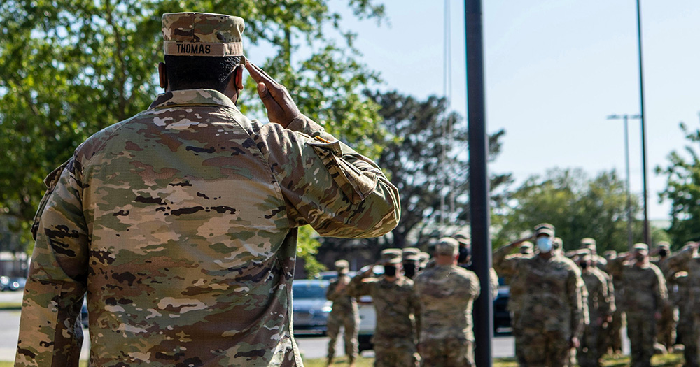 This article is about the US Supreme Court ruling in favour of enforcing the trans military ban. The image shows the back of a soldier saluting.