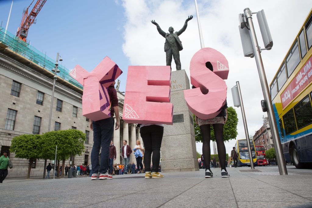 Photo provided by the National Library of Ireland, with three people standing with big cardboards that read YES.
