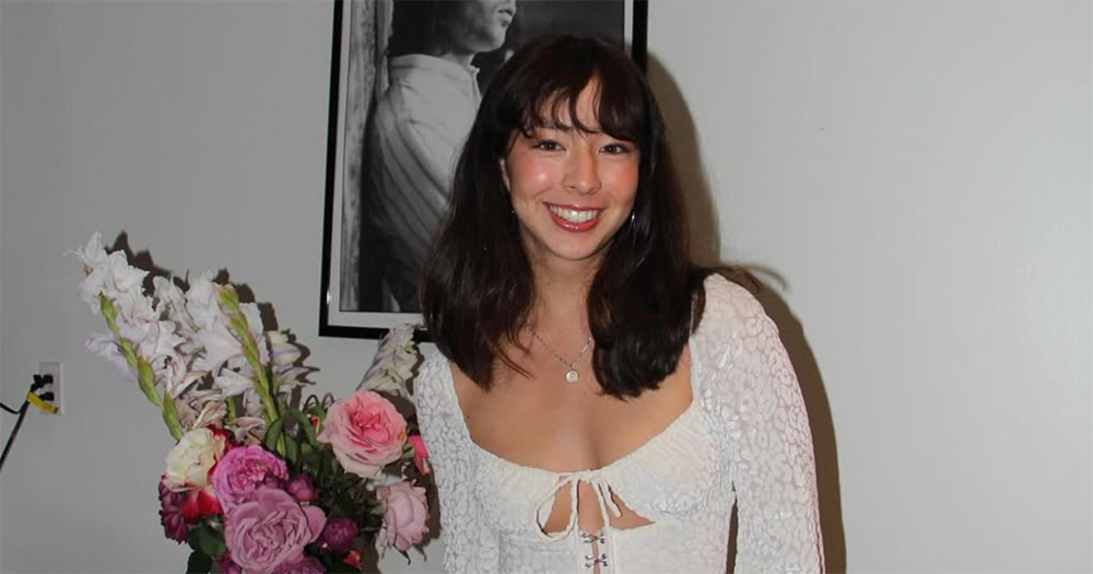 Aubrey Anderson-Emmons smiling for a photo wearing a white dress.