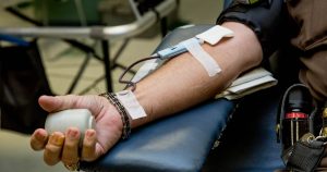 This article is about blood donation rules in Australia. In the photo, the arm of a man donating blood.