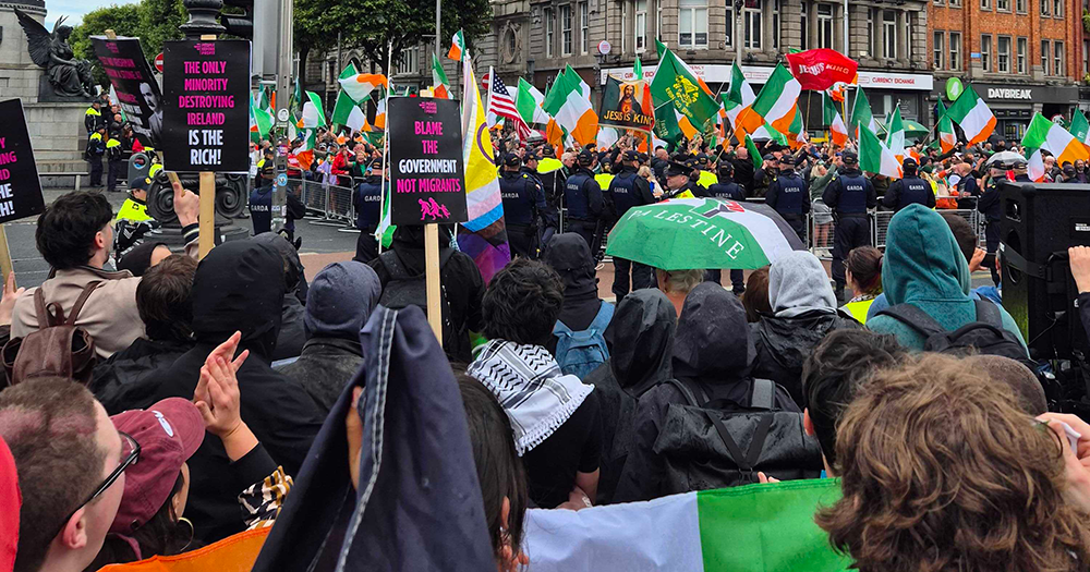 Image of the anti-immigration and anti-racism protests in Dublin. There are large crowds with various flags and signs on show.